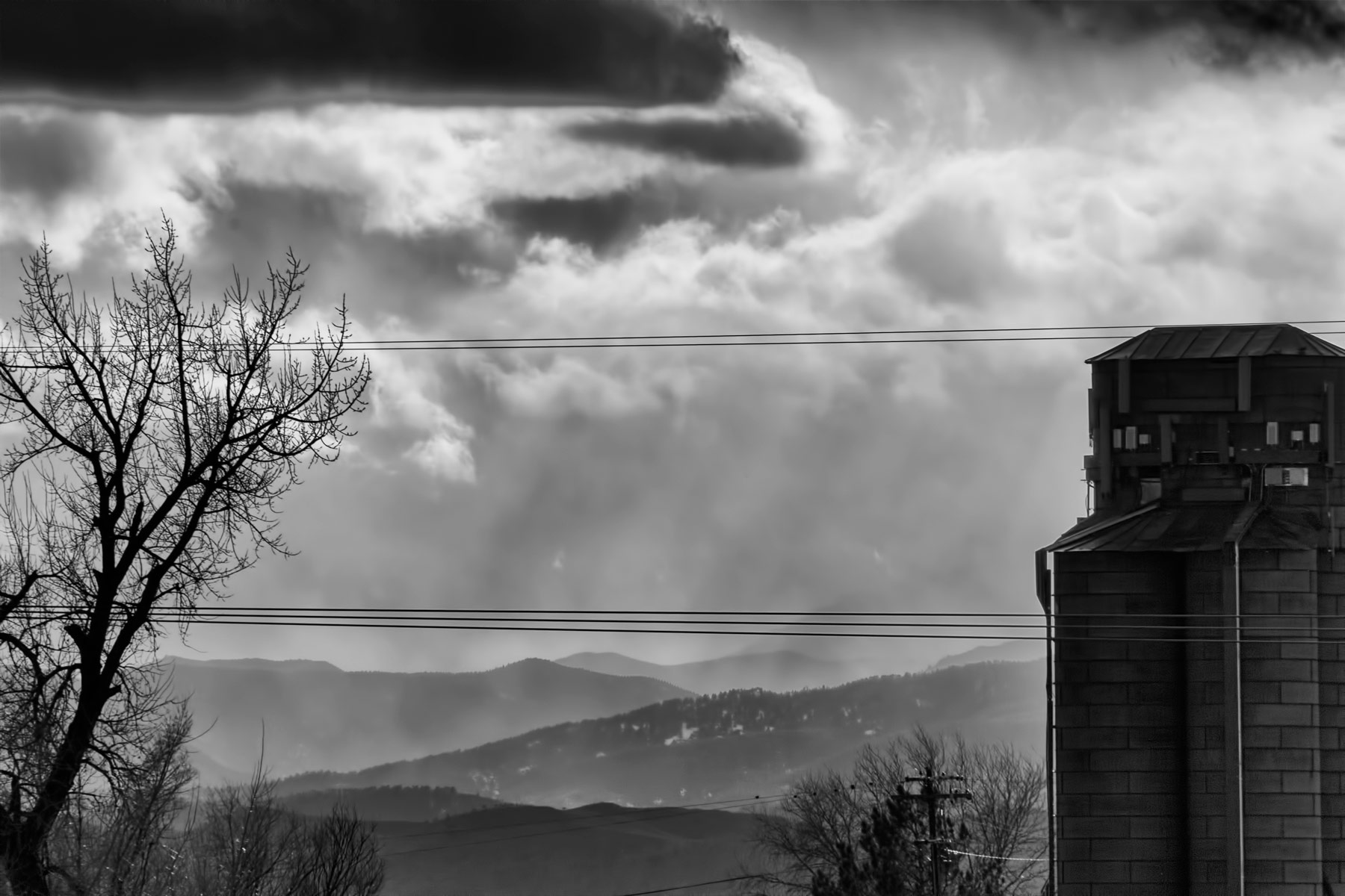 Solitary Silo – Black and white photograph of a silo against the backdrop of the foothills.